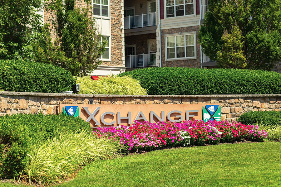 Beautifully landscaped lawn adorned with vibrant flowers in front of the signage of a meticulously maintained commercial property