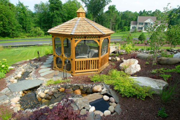 Wooden gazebo surrounded by plants is an amazing outdoor living space