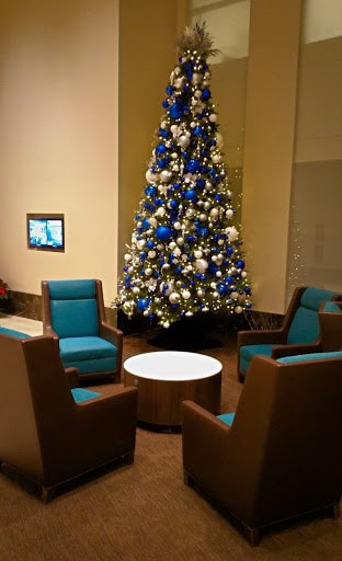 glowing christmas tree with white and blue christmas decor in office setting