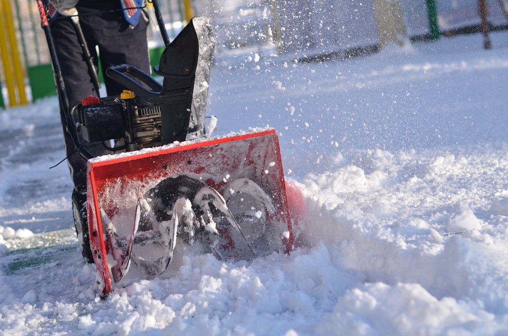 Man using orange snowblower. Our company has a snow certification which represents the level of excellence in the ice management industry and that we adhere to service quality.