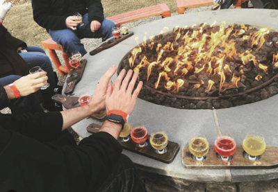 coal burning fire with hand warming near it and drinks